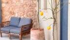 Mediterraner Außenbereich mit Zitronenbaum, Lounge-Möbeln und rustikaler Steinmauer der Luxusfinca in Ses Salines.