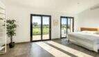 Helles Schlafzimmer der Luxusfinca in Ses Salines mit Terrassenzugang und Blick auf grüne Landschaft