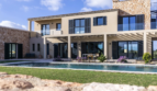 Luxusfinca Ses Salines: Außenpool, Pergola & mediterrane Steinfassade unter blauem Himmel
