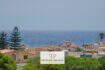 Außenansicht Wohnanlage Porto Cristo mit Meerblick, mediterrane Häuser mit Terrakottadächern und üppiger Vegetation