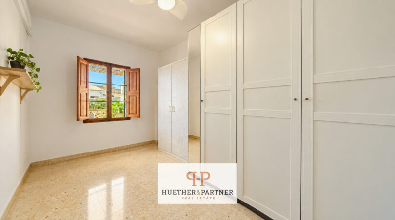 Helles Schlafzimmer mit weißen Einbauschränken, Terrakottafenster und Marmorböden im Stadthaus Manacor