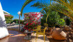 Mediterranean terrace of the sea view villa in Cala Murada with yellow chairs, bougainvillea and palm trees