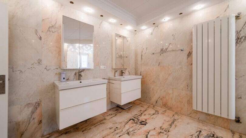 Elegantes Marmorbad mit zwei Waschtischen, Spiegelschränken und Fußbodenheizung in Poolvilla Cala Murada