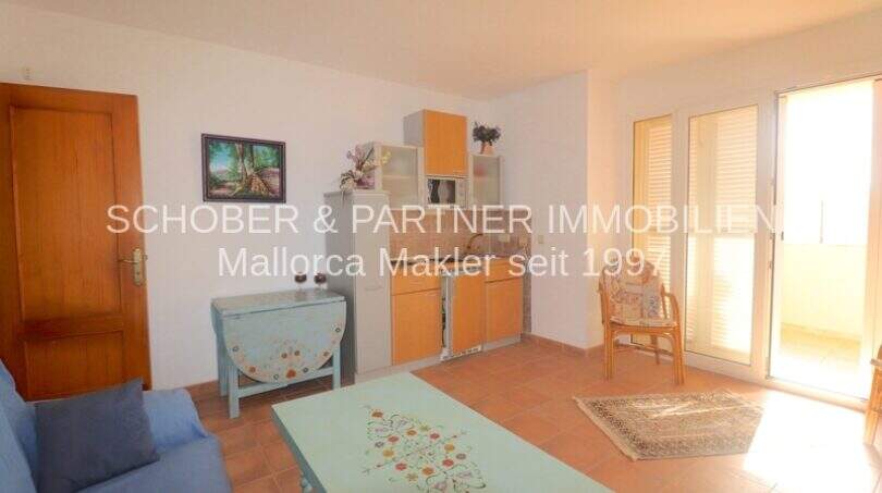 Helles Wohnzimmer mit Küchenzeile, Terrassenzugang und mediterranem Flair im Chalet Sa Coma, Mallorca.