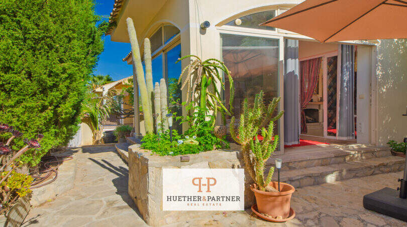 Mediterrane Terrasse mit Kakteen, Natursteinboden und Glasfront in Cala Murada