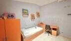 Kinderzimmer mit orangefarbenem Mobiliar, Einzelbett, Schreibtisch und Klimaanlage im Haus mit Ferienlizenz in Muro