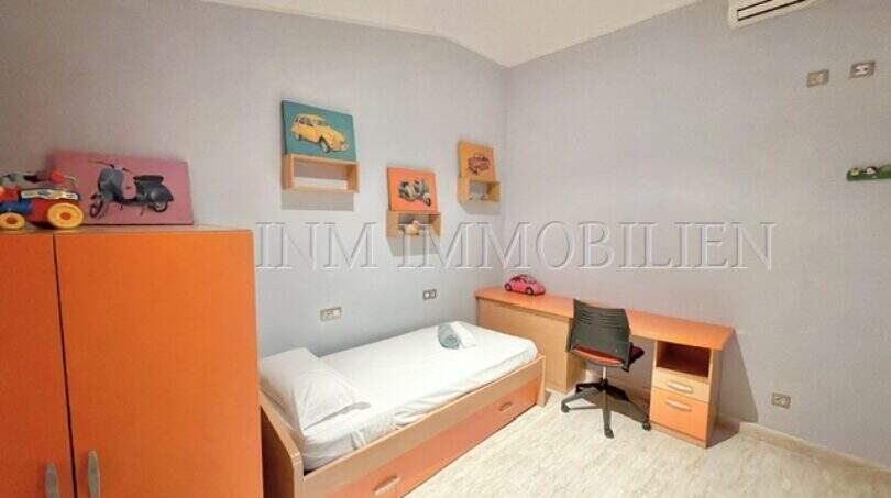 Kinderzimmer mit orangefarbenem Mobiliar, Einzelbett, Schreibtisch und Klimaanlage im Haus mit Ferienlizenz in Muro