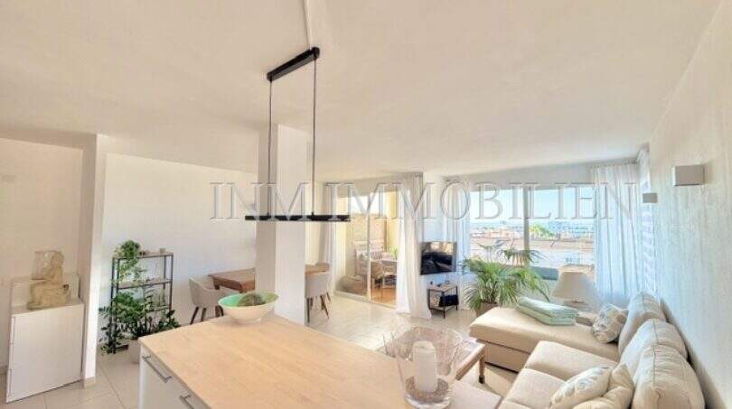 Helles Wohnzimmer mit offener Küche, modernem Sofa und Balkonzugang mit Meerblick in Palmanova
