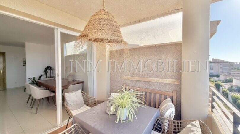 Überdachte Terrasse mit Esstisch, Rattanstühlen und Korblampe der Wohnung in Palmanova