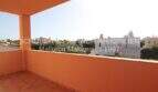 Sonnige Dachterrasse mit orangefarbener Brüstung und Blick über die Dächer von Sa Coma in Meeresnähe.