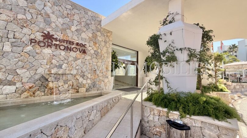 Eingangsbereich der Suites Roc Portonova in Palmanova mit Natursteinwand, Wasserspiel und gepflegter Außenanlage.