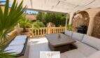 Überdachte Terrasse mit Loungemöbeln, Steinwand und Grillbereich der Strandvilla in Porto Cristo Novo