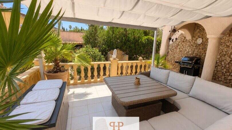 Überdachte Terrasse mit Loungemöbeln, Steinwand und Grillbereich der Strandvilla in Porto Cristo Novo