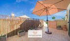 Sonnige Dachterrasse mit Sonnenschirm, Kräuterbeeten und Bambuswand in Cala Murada
