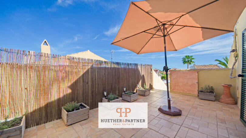 Sonnige Dachterrasse mit Sonnenschirm, Kräuterbeeten und Bambuswand in Cala Murada