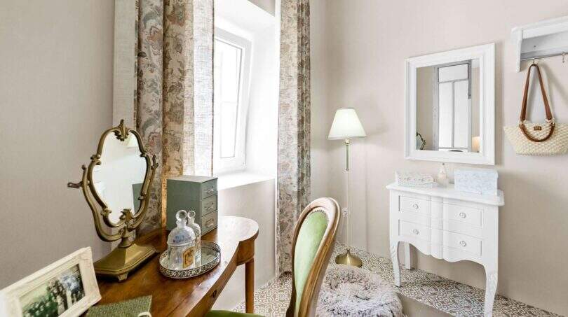 Elegante vestidor con tocador de madera antigua, espejo vintage y cómoda blanca en Felanitx