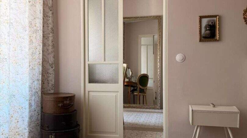 Sala de estar elegante con puerta corredera de cristal, alfombra redonda y decoración vintage en la casa urbana de Felanitx