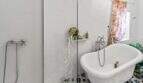 Elegante baño con bañera exenta, mampara de cristal, ducha y baldosas con patrón en casa urbana Felanitx