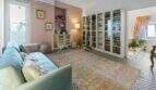 Sala de estar con sofá azul, estantería, piso de mosaico y pared rosa en casa urbana Felanitx