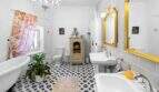 Baño elegante con lámpara de araña, bañera estilo claw-foot, espejo con marco dorado y patrón de azulejos en blanco y negro en la casa urbana de Felanitx