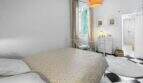 Dormitorio luminoso con cama doble, piso de tablero de ajedrez y baño en suite en casa urbana Felanitx