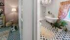 Elegante baño con bañera exenta, lámpara de araña y piso de baldosas blanco y negro en casa urbana Felanitx