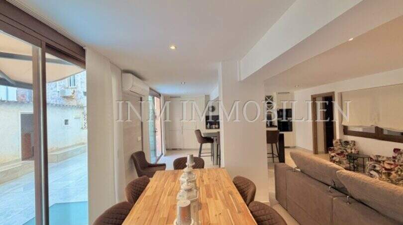 Heller Wohn-Essbereich mit Holztisch, Sofa und großer Glasfront zur Terrasse in sanierter Wohnung, Palma