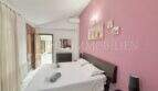 Schlafzimmer mit Doppelbett, rosa Akzentwand, Klimaanlage und Holztüren im Ferienhaus Muro