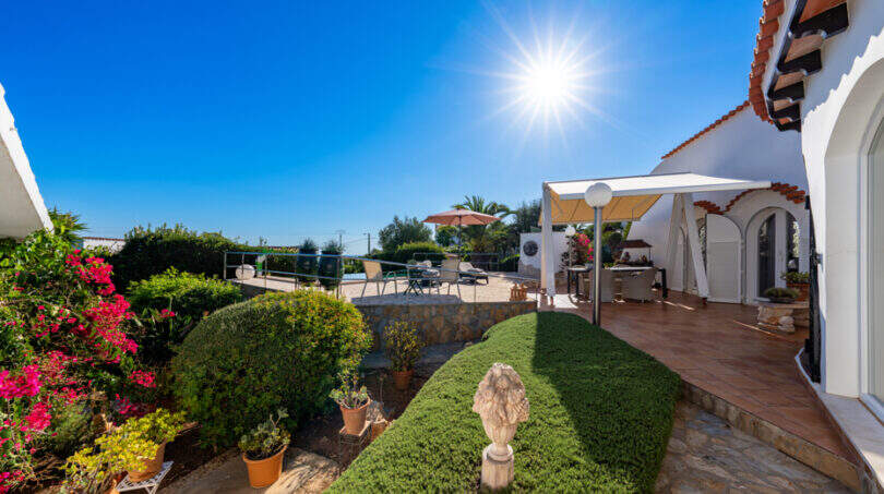 Sunny outdoor terrace of the sea view villa in Cala Murada with pergola, bougainvillea and well-maintained garden