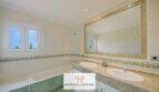 Helles Badezimmer der Finca Santa Maria mit Doppelwaschbecken, Marmor-Waschtisch und Badewanne.