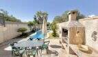 Sonnige Terrasse mit Esstisch, Steinbarbecue und Pool im Ferienhaus Muro, Mallorca