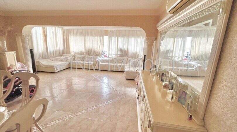 Helles Wohnzimmer mit Marmorböden, weißen Säulen und großen Fenstern in Wohnung in El Arenal, Palma