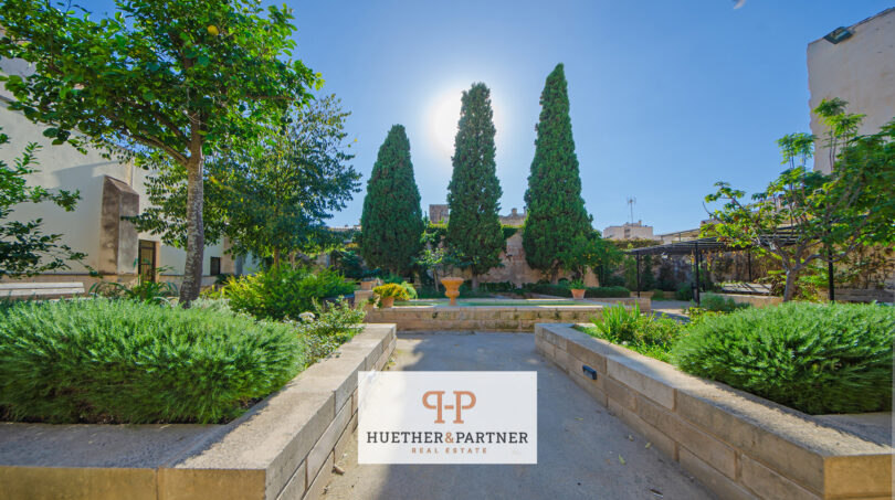 Gepflegter Innenhof mit Zipressen, Springbrunnen und mediterranen Pflanzen im Stadthaus Manacor