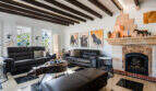 Elegant living room of the sea view villa in Cala Murada with fireplace, wooden beams and leather furnishings