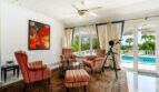 Elegantes Wohnzimmer mit Antiquitäten, Teleskop und Blick auf den Pool der Villa in Cala Murada.