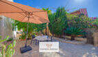 Gepflegte Terrasse mit Sonnenschirm, Sitzgruppe und mediterranem Garten in Cala Murada