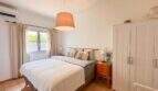Helles Schlafzimmer mit Doppelbett, Pendelleuchte, weißem Kleiderschrank und Klimaanlage im Ferienhaus Santanyí