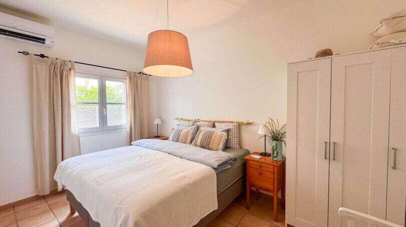 Helles Schlafzimmer mit Doppelbett, Pendelleuchte, weißem Kleiderschrank und Klimaanlage im Ferienhaus Santanyí