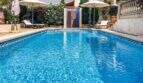 Gepflegter Außenpool mit griechischem Fliesenmuster, Liegestühlen und Sonnenschirmen in exklusiver Villa in Santanyí.
