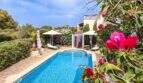 Privater Pool mit Sonnenterrasse, Liegestühlen und üppigem Garten einer exklusiven Villa in Santanyí