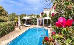 Privater Pool mit Sonnenterrasse, Liegestühlen und üppigem Garten einer exklusiven Villa in Santanyí
