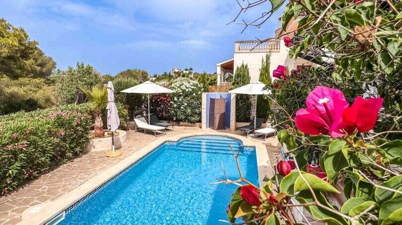 Privater Pool mit Sonnenterrasse, Liegestühlen und üppigem Garten einer exklusiven Villa in Santanyí