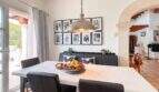 Helles Esszimmer mit Marmortisch, schwarzen Lederstühlen, Pendelleuchte und Galerie-Wand in exklusiver Villa Santanyí