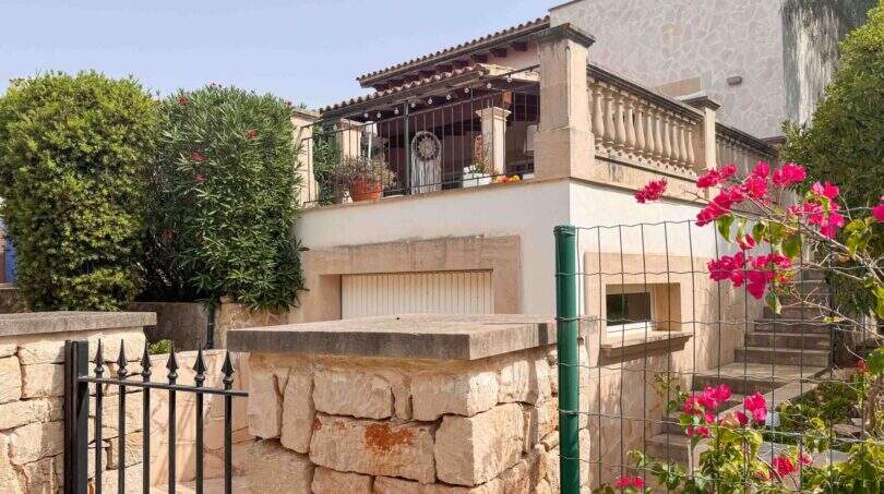 Außenansicht Villa Santanyí mit Balkon, Natursteinmauer, Bougainvillea und mediteraner Bepflanzung in Strandnähe