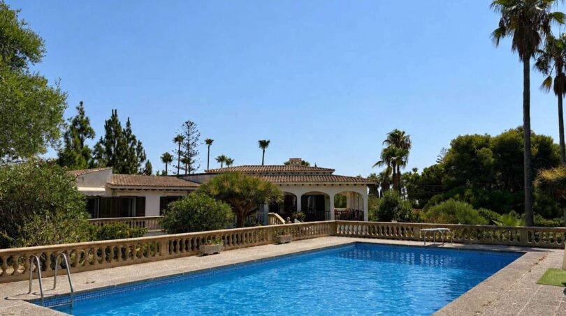 Großer Außenpool mit Balustrade vor mediterraner Villa mit Terrakottadach in Porto Cristo