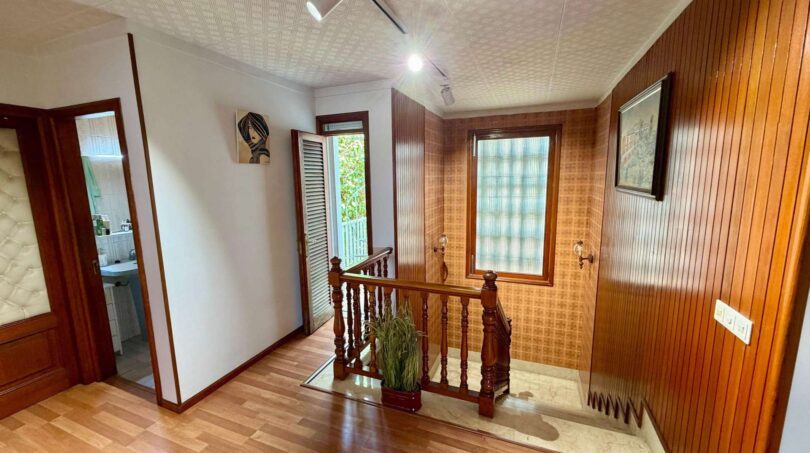 Oberes Treppenhaus der Retro-Villa in Porto Cristo mit Holzvertäfelung, Parkettboden und Holzgeländer.