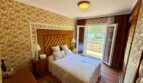 Retro-Schlafzimmer mit goldenem Polsterkopfteil, Balkonzugang und floralem Tapetenmuster in Villa Porto Cristo