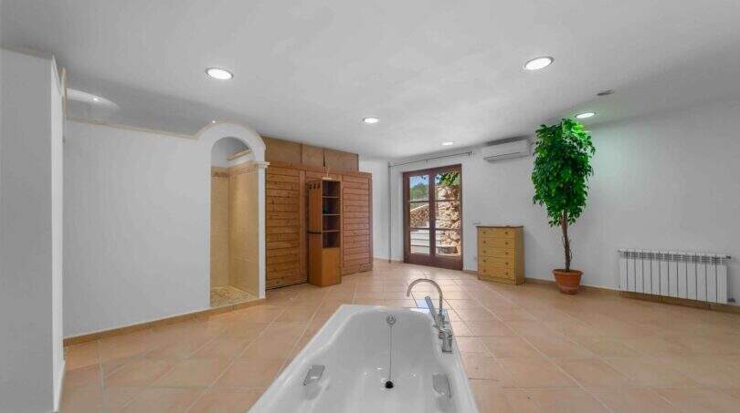 Großzügiges SPA-Bad der Finca in Cala Murada mit Einbaubadewanne, Sauna, Klimaanlage und Natursteinboden