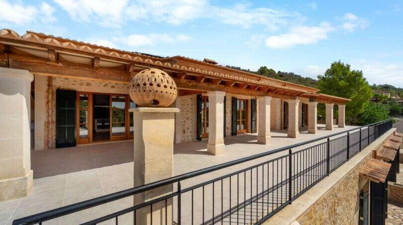Weitläufige Terrasse der mallorquinischen Finca in Cala Murada mit Natursteinmauern und Holzdachkonstruktion