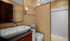 Modernes Badezimmer der Finca Cala Murada mit Aufsatzwaschbecken, Glasdusche und rotem Waschtischunterschrank.